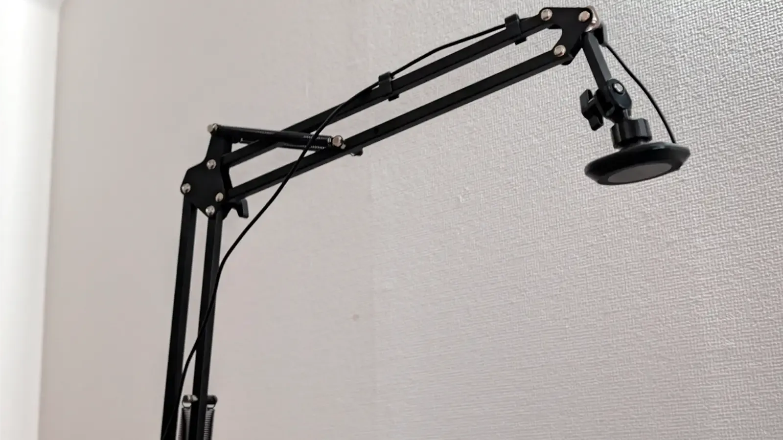 ベッドサイドに設置されたQi2対応のアーム式ワイヤレス充電器